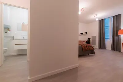 a bedroom with white walls and a bed in a room at La PARERIE 2 in Carcassonne