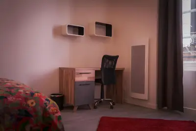 a bedroom with a desk and a chair and a desk with a computer at La PARERIE 2 in Carcassonne