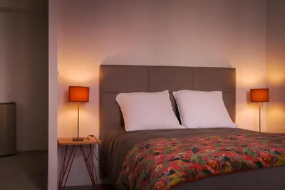 a bedroom with a large bed with two lamps at La PARERIE 2 in Carcassonne