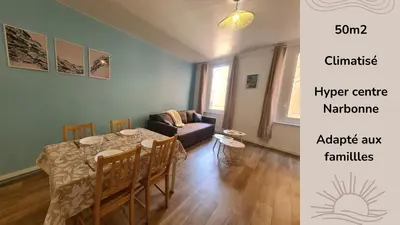 a living room with a table and a couch at Douces Vagues - hypercentre climatisé in Narbonne