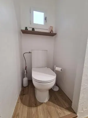 a bathroom with a white toilet and a window at Douces Vagues - hypercentre climatisé in Narbonne