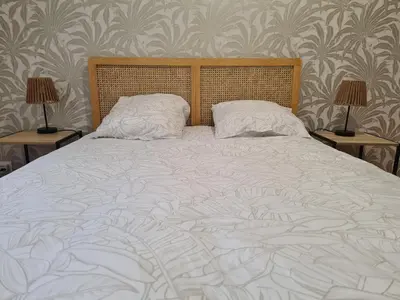 a large white bed with two lamps on two tables at Douces Vagues - hypercentre climatisé in Narbonne