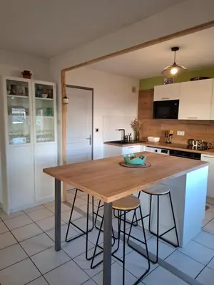 a kitchen with a wooden table and some bar stools at Joli Appt La Pérouse, 2 Chbres, Centre ville, Jardin in Castres