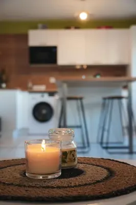 a candle in a glass jar on a table at Joli Appt La Pérouse, 2 Chbres, Centre ville, Jardin in Castres