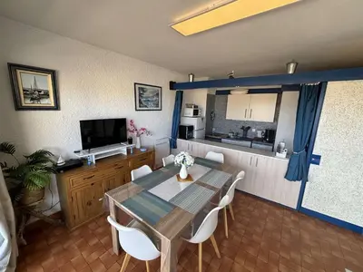 a dining room with a table and a kitchen at Appart 2 pièces Cabine PORT LA NOUVELLE PN590-022 in Port-la-Nouvelle