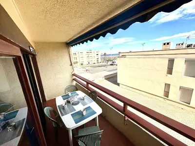 a balcony with a table and a view of a building at Appart 2 pièces Cabine PORT LA NOUVELLE PN590-022 in Port-la-Nouvelle