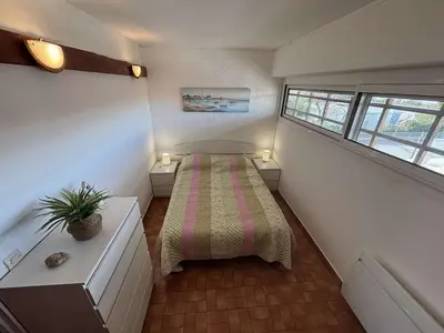 a small room with a bed and two windows at Appart 2 pièces Cabine PORT LA NOUVELLE PN590-022 in Port-la-Nouvelle