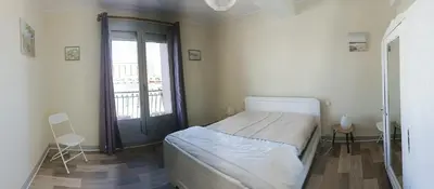 a bedroom with a bed and a large window at La Voile Méditerranéenne in Port-la-Nouvelle