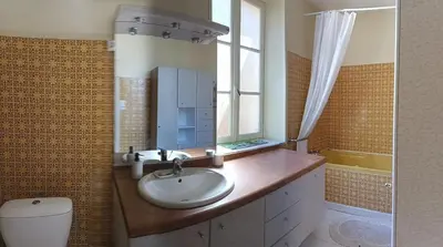 a bathroom with a sink and a toilet and a window at La Voile Méditerranéenne in Port-la-Nouvelle