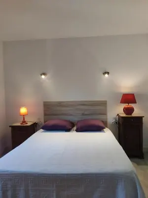 a bedroom with a bed with two pillows and two lamps at Chambre d'hôtes Zen à Mazamet, avec garage vélos motos in Mazamet
