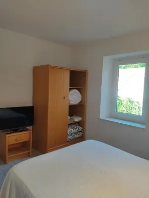 a bedroom with a bed and a cabinet and a window at Chambre d'hôtes Zen à Mazamet, avec garage vélos motos in Mazamet