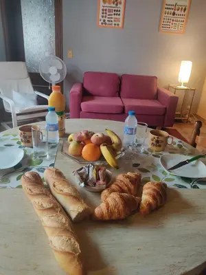 a table with a bunch of croissants and fruit on it at Chambre d'hôtes Zen à Mazamet, avec garage vélos motos in Mazamet