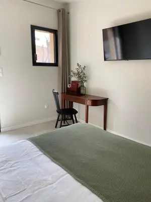a bedroom with a bed and a desk and a chair at Chambre d'Hôtes Dahlia - Boutenac in Boutenac