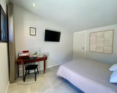 a bedroom with a bed and a desk with a computer at Chambre d'Hôtes Dahlia - Boutenac in Boutenac
