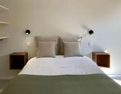 a bedroom with a white bed with two night stands at Chambre d'Hôtes Dahlia - Boutenac in Boutenac
