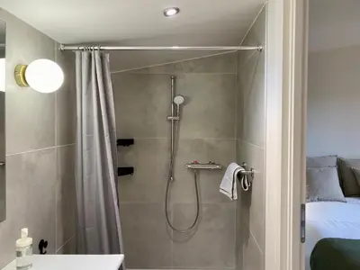 a bathroom with a shower with a shower curtain at Chambre d'Hôtes Dahlia - Boutenac in Boutenac