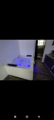 a white bath tub with blue lights in a room at Élégant studio avec jacuzzi in Saint-Paul-de-Fenouillet