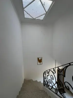 a staircase in a white room with a skylight at Élégant studio avec jacuzzi in Saint-Paul-de-Fenouillet