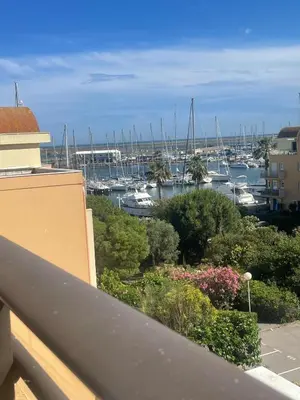 a balcony with a view of a marina with boats at Évasion Méditerranéenne in Gruissan