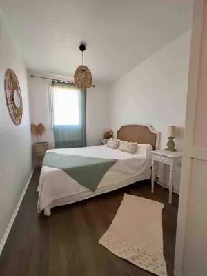 a bedroom with a large bed and a window at Évasion Méditerranéenne in Gruissan