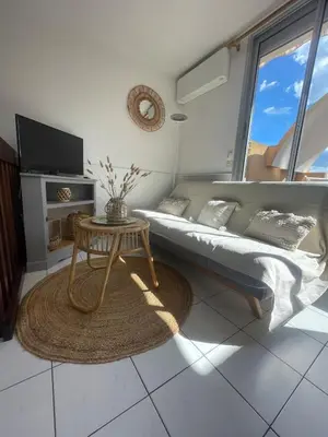 a living room with a bed and a table at Évasion Méditerranéenne in Gruissan