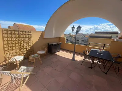 a balcony with tables and chairs and a street light at Évasion Méditerranéenne in Gruissan