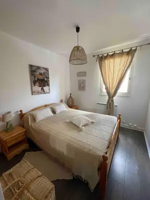 a bedroom with a large bed and a window at Évasion Méditerranéenne in Gruissan
