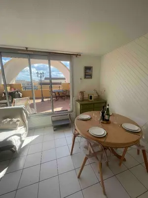 a living room with a table and a view of the ocean at Évasion Méditerranéenne in Gruissan