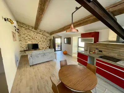 a kitchen and living room with a wooden table in a room at Gite charme et confort in Sainte-Vallière