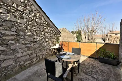 a patio with a table and chairs on a balcony at Gite charme et confort in Sainte-Vallière