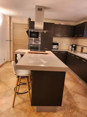 a kitchen with black cabinets and a white counter top at Villa Monze in Carcassonne