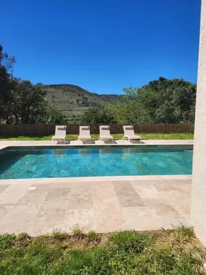 a swimming pool with lounge chairs in a yard at Villa Monze in Carcassonne