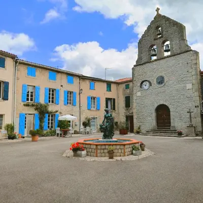 a building with a clock tower and a statue in front of it at Les lits de Montbel B&B in Sonnac-sur-lʼHers