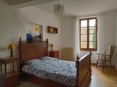 a bedroom with a bed with a wooden frame at Les lits de Montbel B&B in Sonnac-sur-lʼHers