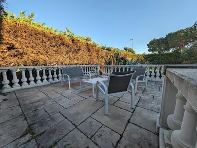 a patio with two chairs and a fence at La Plénitude in Narbonne