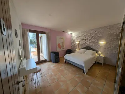 a bedroom with a bed and a desk and a window at La Plénitude in Narbonne