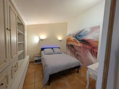 a bedroom with a bed with a painting on the wall at La Plénitude in Narbonne