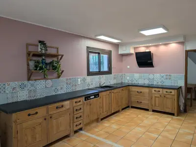 a large kitchen with wooden cabinets and a black counter top at La Plénitude in Narbonne
