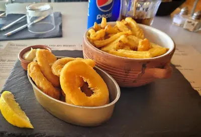 a bowl of fried onion rings and a bowl of fries at Studio Cosy, proche du port, tout se fait à pied in Port-la-Nouvelle
