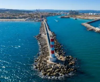 a lighthouse in the middle of a body of water at Studio Cosy, proche du port, tout se fait à pied in Port-la-Nouvelle