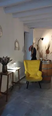 a yellow chair in a living room with a table at Gîte le Calsou 4 étoiles 3ch MontagneNoire Chât Cathare Carcassonne jardin rivière in Caudebronde