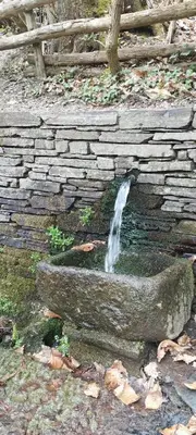 a water fountain in a stone wall with a waterfall at Gîte le Calsou 4 étoiles 3ch MontagneNoire Chât Cathare Carcassonne jardin rivière in Caudebronde