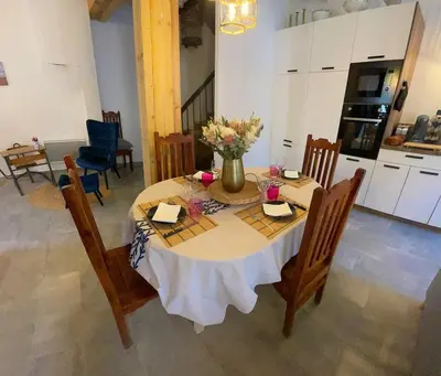 a dining room table with a vase of flowers on it at Gîte le Calsou 4 étoiles 3ch MontagneNoire Chât Cathare Carcassonne jardin rivière in Caudebronde