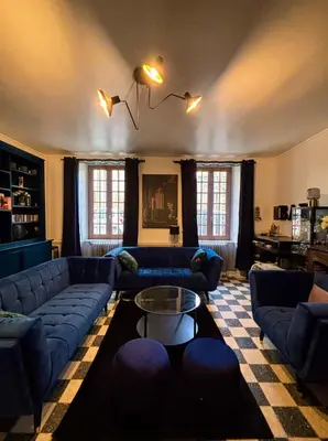 a living room with blue couches and a table at Babouz Cottage in Mirepoix