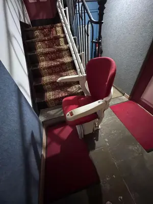 a red chair sitting next to a set of stairs at Appartement Centre Ville in Mirepoix