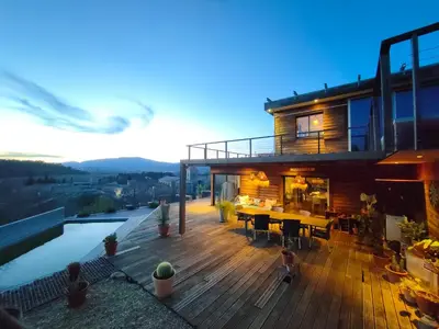 a house with a deck with a table and a pool at Maison contemporaine en bois au coeur des Corbières in Ferrals-lès-Corbières