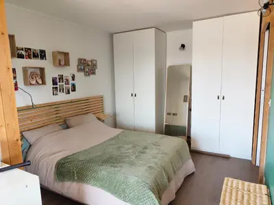 a bedroom with a large bed and white cabinets at Maison contemporaine en bois au coeur des Corbières in Ferrals-lès-Corbières