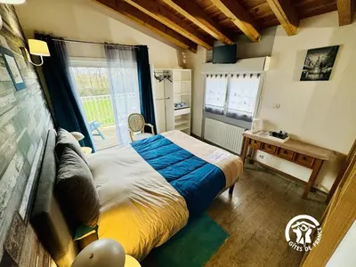 a bedroom with a large bed and a window at La cazabanelle in Villegly