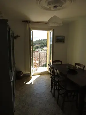 a dining room with a table and a door to a balcony at BELESTAGITE7 Pays Catalan 66 in Bélesta