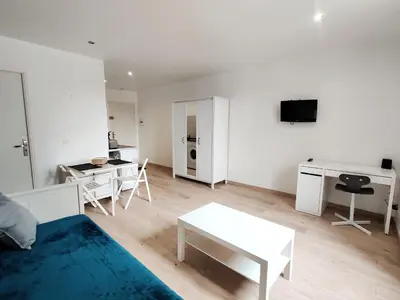 a white living room with a couch and a table at Le Nid du Pont Neuf in Pamiers